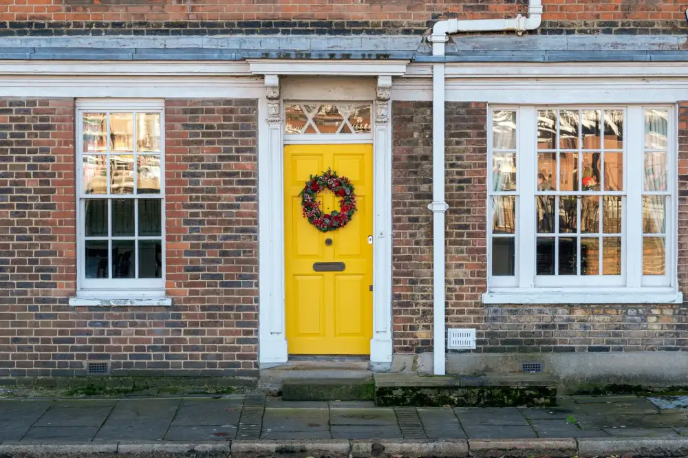 Yellow front door on a red-brick Victorian house – residential locksmith Boston front door security check by Locksmith Boston
